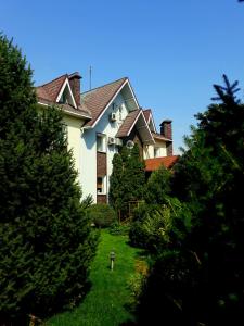 una casa grande con árboles delante de ella en Asian Mountains en Bishkek