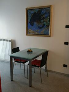 een tafel met twee stoelen en een schilderij aan de muur bij Morbegno house in Morbegno