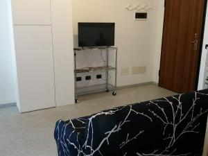 een woonkamer met een bank en een flatscreen-tv bij Morbegno house in Morbegno