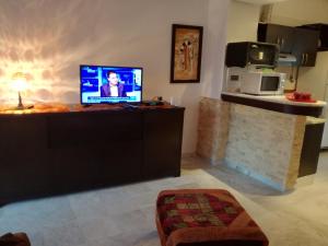 a living room with a television on a table at Sonny Apartment in Hammamet