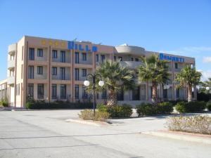 un edificio con palmeras delante en Hotel Villa Damanti, en Licata