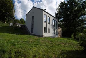 ein weißes Haus auf einem Grashügel in der Unterkunft Lessilou in Mormont