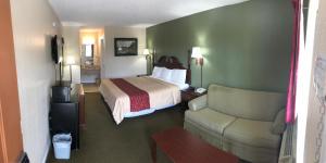 a hotel room with a bed and a chair at Motor Inns Of America in Madisonville +36 photos
