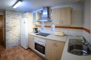 una pequeña cocina con fregadero y nevera. en Apartamento 90 m2 en la mejor zona de Roquetas, en Roquetas de Mar