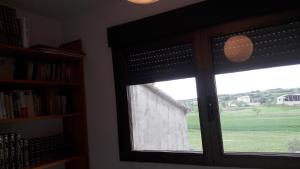 a window with a view of a green field at Casa Sariñena in Adahuesca