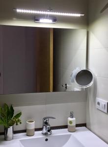 y baño con lavabo y espejo. en A Coastine - alojamiento moderno para viajes de trabajo u ocio a Vigo y alrededores en Ponteareas