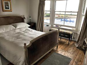 ein Schlafzimmer mit einem Bett und einem großen Fenster in der Unterkunft Smugglers Cottage in Hastings