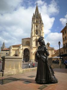 Una statua di una donna in piedi di fronte a un edificio di Los Prados - HUCA Oviedo - Parking gratuito a Oviedo