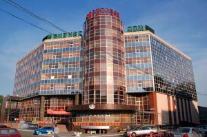 a tall building with cars parked in front of it at Апартаменты ИннХоум с джакузи у БД Спиридонов in Chelyabinsk