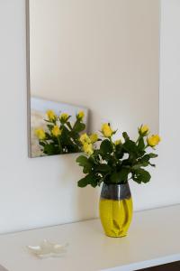 a yellow vase with yellow flowers sitting on a shelf at Dulce Mare in Salerno