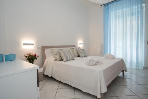 a bedroom with a white bed and a window at Dulce Mare in Salerno