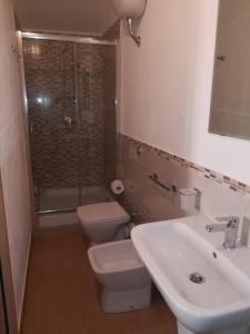 a bathroom with a toilet and a sink and a shower at Mare d'Amuri in Porto Empedocle +17 photos