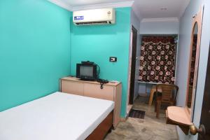 ヴィシャカパトナムにあるヴァニ ロッジのベッドルーム1室(ベッド1台付)、テレビが備わるアパートメントです。