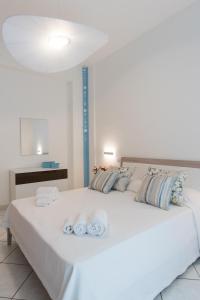 a bedroom with a large white bed with towels on it at Dulce Mare in Salerno