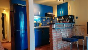a kitchen with blue cabinets and a brick fireplace at Apartment Stinica 26 E in Jablanac