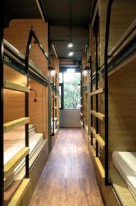 a row of empty beds in a room with a window at DONGMEN 3 Hostel in Taipei