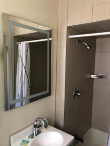 a bathroom with a sink and a shower with a mirror at Monticello Motel in Portland +34 photos