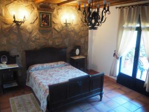 a bedroom with a bed and a stone wall at Hotel Rural El Convento in Valencia de Alcántara