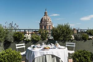 un tavolo con una tovaglia bianca e un edificio di Residenza Napoleone III a Roma