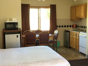 uma cozinha com uma cama e uma mesa com cadeiras em Monticello Motel em Portland