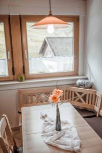 um vaso de flores sobre uma mesa com uma janela em Ferienparadies Hugenhof em Simonswald