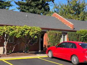 um carro vermelho estacionado em frente a uma casa em Monticello Motel em Portland