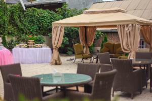 eine Terrasse mit Tischen, Stühlen und einem Sonnenschirm in der Unterkunft Orchid Boutique Hotel in Tbilisi City