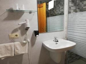 a bathroom with a sink and a phone on the wall at Labella María in Pinos Genil