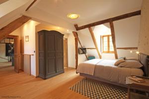 a bedroom with a bed and a wooden floor at Gite de la Coispillière in Ceton