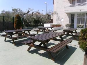 a group of picnic tables and benches on a patio at Apartamentos Miami in L'Estartit