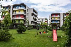 une cour avec une aire de jeux et des immeubles d'appartements dans l'établissement Luxury Radox Apartment Airport Bucharest, à Otopeni