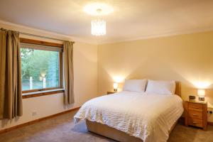 a bedroom with a bed and a window at North Balkello Cottage in Dundee