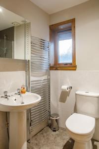 a bathroom with a white toilet and a sink at North Balkello Cottage in Dundee