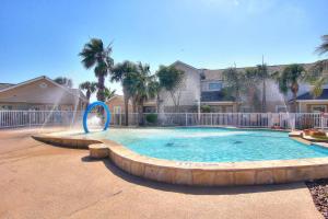 a large swimming pool with a fountain in a yard at Palm Bay Condos in Padre Island