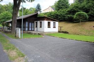 a small white house with a driveway in front of it at Bungalov Rozarka in Růžová