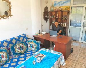 a man is sitting at a desk with a laptop at Maison de la Lagune in Oualidia