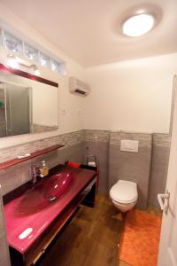 a bathroom with a red sink and a toilet at 10 House in Budapest