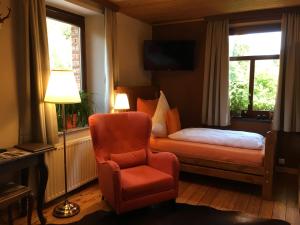 ein Schlafzimmer mit einem Bett, einem Stuhl und einem Fenster in der Unterkunft Bed & Breakfast Schlommefurth in Sankt Vith