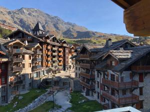 eine Gruppe von Gebäuden mit Bergen im Hintergrund in der Unterkunft Arc 1950 - derniére étage in Arc 1950