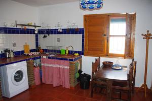 a kitchen with a washing machine and a washer at Casa Feliz in Iznate