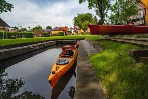 two kayaks are lined up on the side of a canal at Ferienappartements Am Spreewaldfliess in Schlepzig