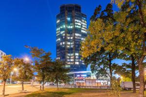 a tall building in a city at night at Luxury Panoramic Vilnius apartment in Vilnius