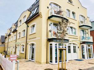 a large yellow building with a balcony on it at Ankerplatz-Sylt @Haus Mateika in Westerland