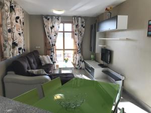 a living room with a green table and a couch at Casa Cerezos in Cala de Finestrat