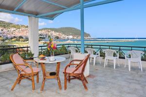 a patio with chairs and a table with a view of the ocean at Mamma Mia in Skopelos Town