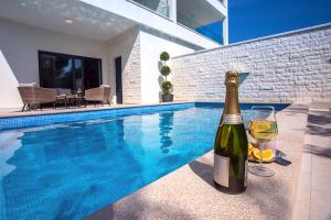 卡什泰拉Villa Filip的游泳池旁的一瓶葡萄酒和玻璃杯 更多41张照片