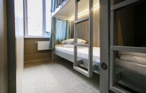 een kleine kamer met een stapelbed en een raam bij Hostel Sleep Space in Kazan