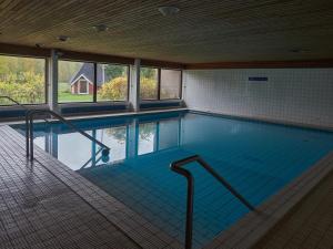 a large swimming pool in a building with windows at Hotelli Pielinen in Vuonislahti