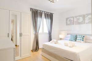 a white bedroom with a bed and a window at Picasso Daisy in Fuengirola