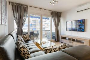 salon z kanapą i szklanym stołem w obiekcie Picasso Daisy w mieście Fuengirola